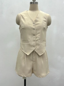 Détail de l'ensemble gilet beige à col en V et short plissé à taille haute