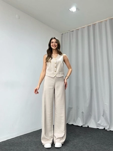 Detailed view of beige two-piece set featuring a buttoned vest and wide-leg trousers