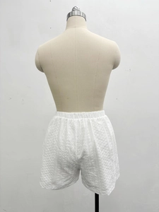 Detail of white hollow-out embroidery shorts with elastic waist on a mannequin