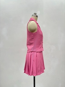Détail d'un ensemble rose deux pièces avec gilet sans manches et mini-jupe plissée