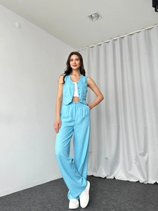 Detailansicht der hellblauen ärmellosen Weste und der passenden weiten Hose am Modell