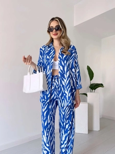 Détail du motif zébré bleu et blanc sur une chemise fluide à manches longues et un pantalon