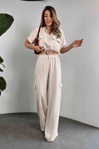 Détail d'un crop top crème à manches courtes et d'un pantalon cargo assorti à jambes larges