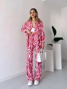 Détail d'un ensemble chemise à manches longues et pantalon large à imprimé zébré rose