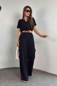 Détail d'une chemise utilitaire noire à manches courtes et d'un pantalon cargo large
