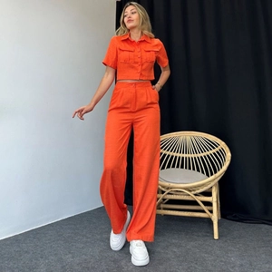 Women's two-piece bright orange summer set with button-down shirt and high-waisted wide trousers