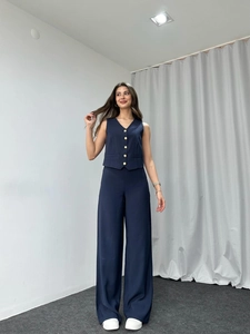 Detail of dark blue two-piece set featuring a V-neck vest and high-waist wide-leg trousers