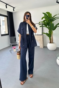 Detail view of navy blue two-piece set featuring drawstring shirt and wide-leg trousers