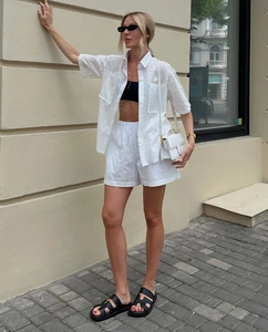Detail of white eyelet hollow-out short sleeve shirt and high waist shorts two-piece set