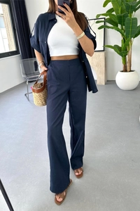 Detail of navy blue linen blend short sleeve shirt and high waist wide leg trousers