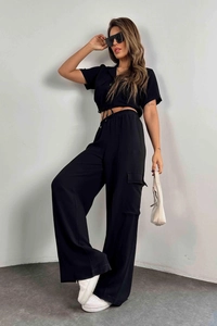 Détail du crop top avec cordon de serrage et poches cargo sur l'ensemble noir