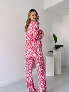 Vue détaillée du motif zébré rose et blanc sur le pantalon large et la chemise à manches longues