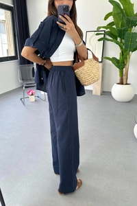 Detail of dark blue short sleeve linen shirt and high waist wide leg pants set with belt