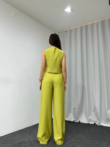Rear view of vibrant grass green two-piece suit set with vest and wide-leg trousers