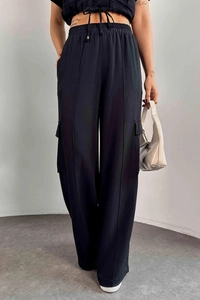 Détail du pantalon cargo noir à taille haute avec cordon de serrage et poches latérales