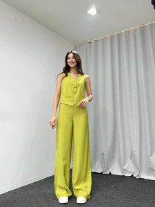 Detail of lime green V-neck buttoned vest and high-waist wide-leg trousers set