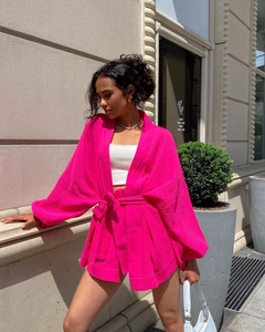 Détail de l'ensemble d'été fuchsia avec haut noué et short en tissu texturé respirant