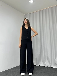 Detail of black two-piece set featuring V-neck sleeveless vest and high-waist wide-leg pants