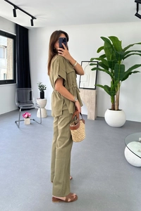 Detail of olive green linen-set with drawstring waist shirt and matching straight pants