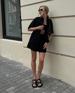 Detail of black hollow-out short-sleeved shirt with matching shorts and inner tube top