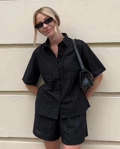 Detail of black eyelet embroidered short sleeve shirt and matching shorts set