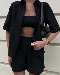 Detail of black eyelet broderie anglaise shirt and matching shorts on a female model