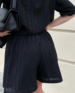 Detail of black hollow out lace texture and intricate floral embroidery on summer set