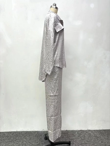 Detail view of leopard print satin pajama set showing long sleeves and button-down shirt