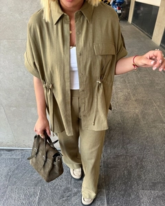 Detailed close-up of olive green linen shirt with drawstring waist and cargo pants set