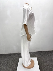 Detail of white cotton linen lounge set featuring a short sleeve collar shirt and wide trousers