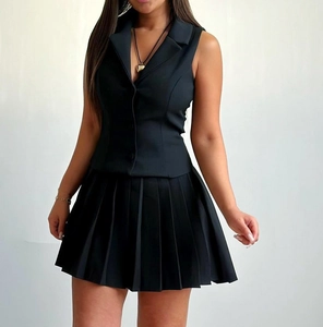 Détail d'un ensemble gilet noir sans manches à revers et jupe plissée courte