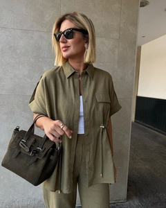 Detail of olive green linen shirt set featuring drawstring waist and utility pockets