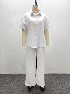 Detail view of white two-piece set featuring a short-sleeve shirt and wide-leg linen pants