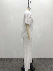Detail of white cotton linen blend two-piece set featuring short sleeve shirt and trousers