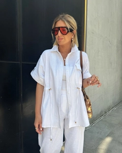 Detail of white short sleeve shirt with drawstring waist and flap pockets design