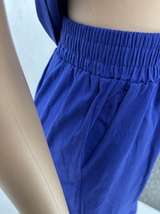 Detail of blue high-waisted wide-leg pants with elastic waist and side pockets