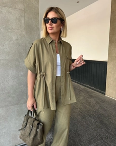 Detailed texture of olive green linen short sleeve shirt with drawstring waist detail