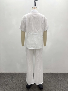 Detail of white cotton linen blend short sleeve shirt and loose trousers on mannequin