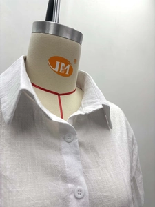 Detail of white lapel shirt with natural cotton-linen texture and white round buttons