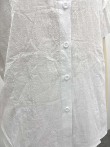 Detail of white linen fabric texture and single-breasted button design on a summer shirt