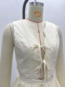 Détail du gilet vintage en coton beige avec fermeture à lacets et décolleté en V