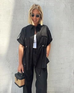 Close-up of black short sleeve shirt featuring adjustable drawstring and metal hardware detail