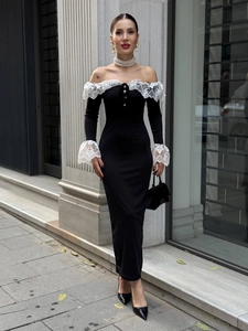 Détail de l'encolure à épaules dénudées avec dentelle blanche sur une robe noire moulante