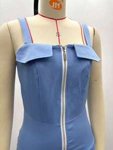Détail de robe bleue moulante avec fermeture éclair blanche et revers décoratif