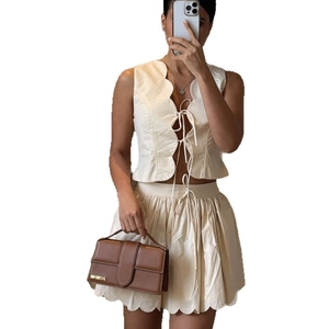 Ensemble deux pièces crème pour femme avec gilet à volants et mini-jupe plissée assortie