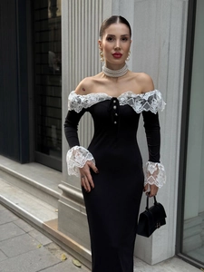 Détail de robe noire avec dentelle blanche à l'encolure et boutons en perles