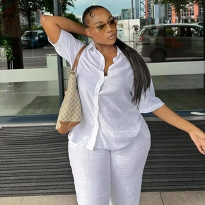 Women's minimalist white linen set featuring short sleeve button shirt and loose trousers