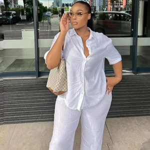 Elegant white minimalist women's linen shirt and loose wide-leg trousers set for summer