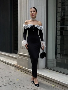 Détail d'une robe élégante à épaules dénudées avec dentelle blanche sur fond noir