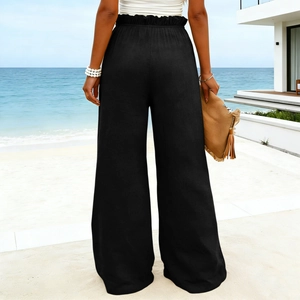 Rear view of black high waist wide leg pants with ruffled elastic waistband on beach